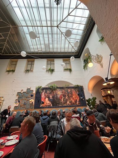 People sitting at tables below a very high glass ceiling